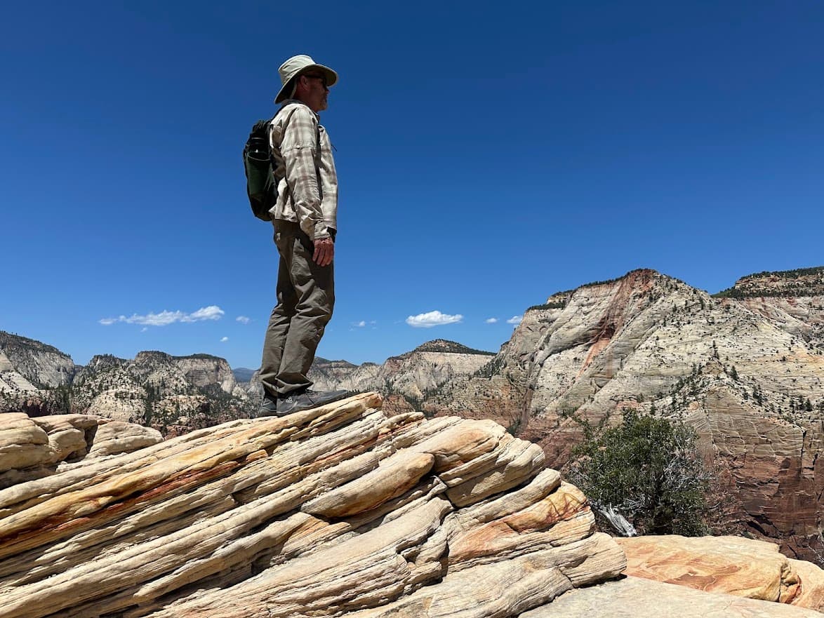 Robert Trupe standing on a canyon rock, surveying vast peaks